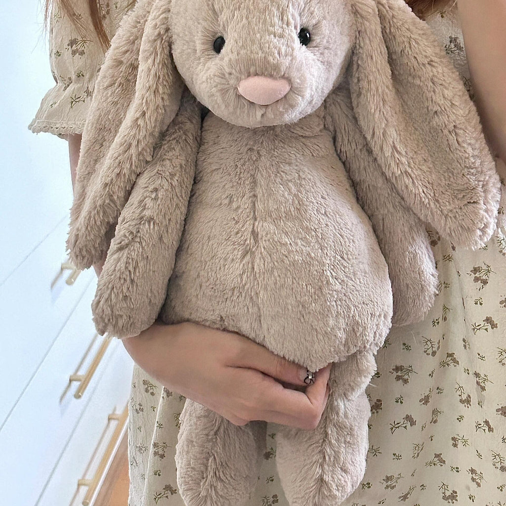 Cute bashful bunny plush toy held in hand, fluffy lop ear stuffed rabbit emotional companion